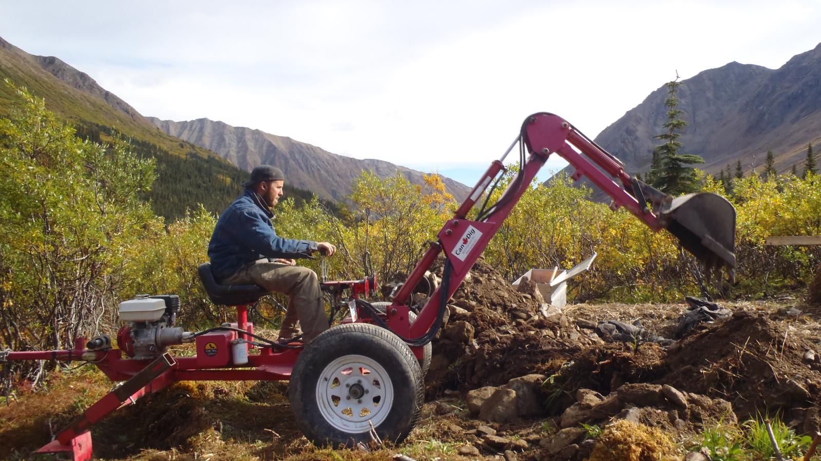 Candig mini excavator at work digging a trench for sampling