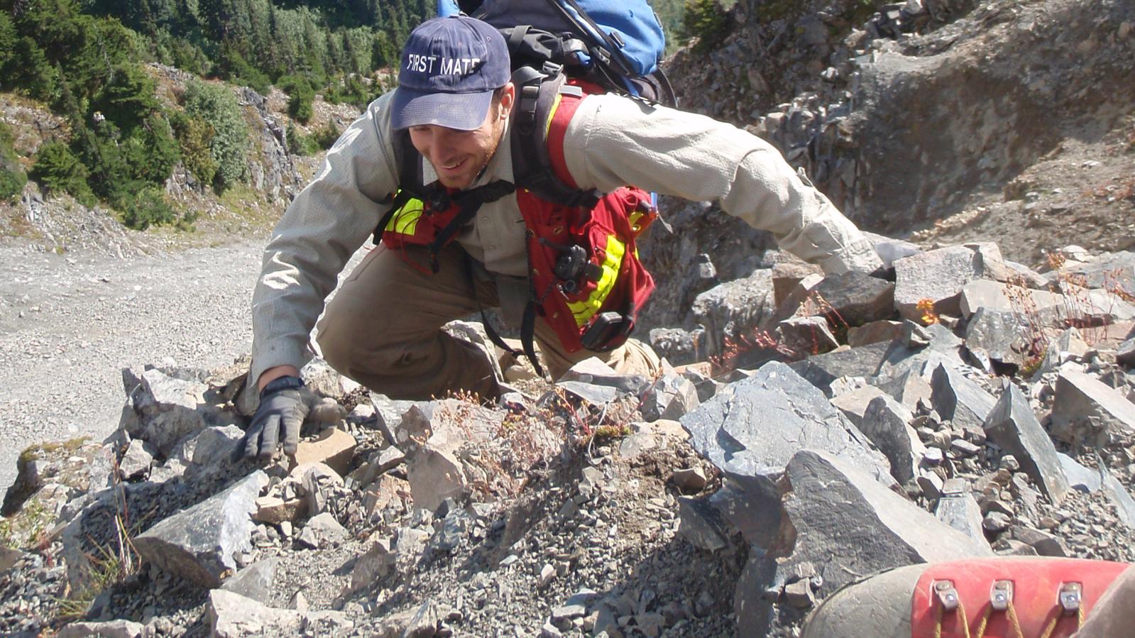 Exploration crew member climbing a very steep slope in northwest BC