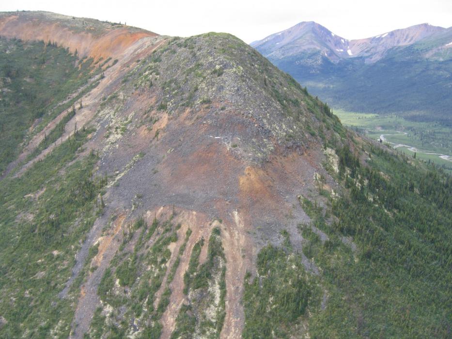 Pelly Mountain Project - Ice Claims Gossanous Volcanics with Drill Pad at Center of the Brown Weathered Volcanics