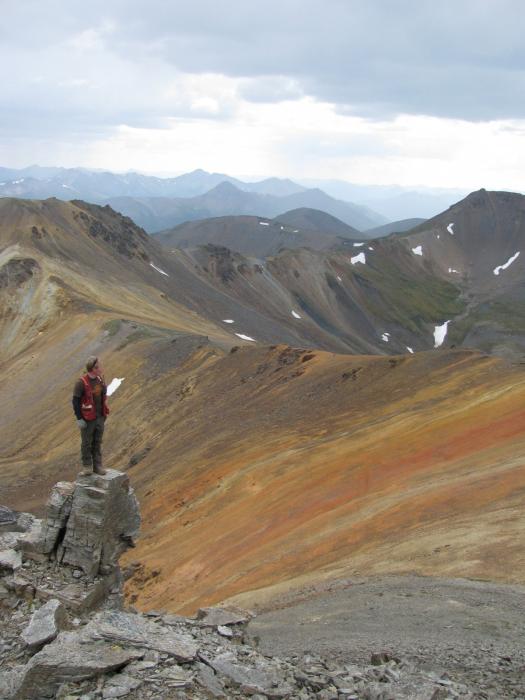 Mineral Explorer on Outcrop at a Gossanous Ridge of the MM Critical Minerals Exploration Project Yukon Territory
